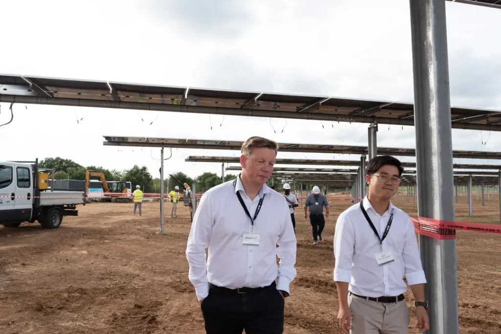 Michael Bruhn Hansen and Korn Maneewannakul from Glentra beneath one of the elevated trackers at the Vetralla agrivoltaic project.